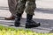 One single anonymous unrecognizable professional soldier standing on the street in traditional generic camo uniform and black