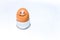 One single brown egg with positive face smiling stands in an egg holder on white backdrop. Drawn black smile