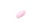 One single pink pill on white background, multivitamin tablet or dietary supplement