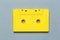 One single retro audio cassette on light grey background, top view