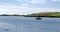 One small motorboat is anchored in Clonakilty Bay on a sunny day. Boat on the surface of the