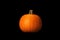 One small orange pumpkin lighten by dramatic studio light