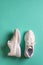 One sneaker stands and the other lies on its side on a green blue background. New white chunky sole shoes for active lifestyle,