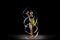 One sportive emotional girl, rhythmic gymnastics artist isolated on dark background in ray of light. Concept of sport