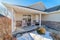 One storey home with rocking chairs on porch overlooking snowy winter scenery