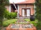 One-storey house in oriental style with panoramic windows of red brick, clay tub with water, stone path