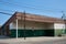 A one-story brick building with metal column supporting the corner, creating an overhang for parking in Brooklyn, NYC