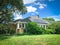 One story bungalow corner house with solar panel on shingle roof in suburbia Dallas, Texas, USA