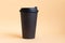 One takeaway black coffee cup on neutral background. Mock-up, nobody, front view, copy space.