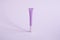 One tall narrow tube for cosmetics lip gloss, cream, purple on a purple background.