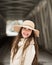 One teenage high school senior portrait wearing floppy hat at covered bridge in winter