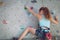 One teenager climbing a rock wall indoor.