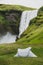 One tent camped with amazing Skogafoss waterfall view. Travel concept.
