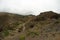 One of the tight turns of a narrow rural road in the mountains of Parque Natural Majona. View of Playa De Caleta the north-eastern