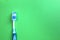 One toothbrush lies on a green background