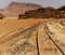 One-track railway with large rock formations in the background, in the desert of Wadi Rum, Jordan