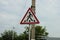 One triangular road sign pedestrian crossing on a pillar on a street