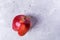 One ugly ripe red  apple on grey concrete background.