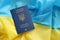 One Ukrainian biometrical passport on folded waving flag of Ukraine country