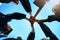 When one of us wins, we all win. Low angle shot of a group of young students joining their hands together on graduation