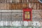 One vintage window with crimson red ornamental frame in brown wooden wall