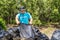 One volunteers in work overalls collect garbage in forest in plastic bag. Close-up during action. Cleaning of nature from waste.