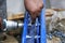 One warehouse worker in with power tool tightening screw during rack arrangement erection work