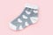 One warm winter women`s socks with print in the shape of hearts isolated over pink background. Valentine\\\'s day gift