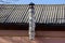 One warmed long metal pipe on a gray slate roof against a blue sky