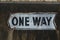 ONE WAY sign on concrete wall