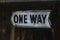 ONE WAY sign on concrete wall