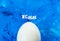 One white chicken egg on a blue abstract background backdrop. Cover concept. Copy space.