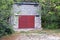 One white cinnamon garage with closed red iron gates