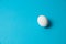 One white egg on a blue background. The concept of calorie content, life, healthy nutrition, Easter