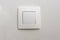 One white light switch, turn on or turn off the lights hanging on the white wall in the room