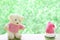 One white teddy bear wear pink shirts with pink Christmas cap on green bokeh background. Concept Christmas day