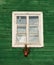 One window in vintage style in green wall background,architecture details. Colorful window fragment.Street scene with the house wi