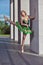 One Winsome Professional Caucasian Ballet Dancer in Green Tutu Dress Posing in Standing Pose With Leg Lifted