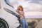 One woman alone traveler smile and look on camera standing against a big modern motorhome camper van enjoying travel and