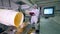 One woman checks work of automated conveyor, moving chips into a container.