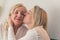 one woman kissing the other on a cheek closeup living room female couple