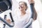 One woman mature or senior at the gym training and doing exercise in on a machine - active pensioner lifestyle and concept