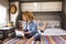 One woman reading a book comfortably sitting on bed inside a camper van modern motorhome alternative tiny cozy house. Relaxation