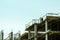 One worker working on the top of the building construction site with scaffold.