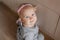 A one-year-old baby in a cute grey dress with a tulle skirt sits on the floor and smiles