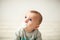 One year old cute baby boy sitting on wooden floor