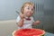 One-year-old girl eats watermelon with a spoon, the first independent use of vitamins, sweet berry