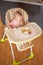 One year old girl having balanced meal in baby eating chair, healthy balanced nutrition for child