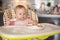 One year old girl having balanced meal in baby eating chair, healthy balanced nutrition for child