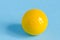 One yellow billiards ball on azure background